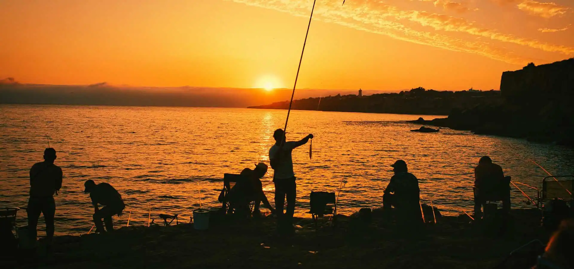 Angler fishing on a lake at sunrise