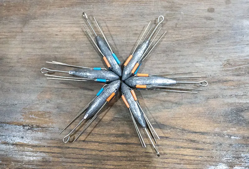 Sputnik sinker fishing weights with wire arms for surf fishing, used to anchor bait in strong currents on sandy beaches